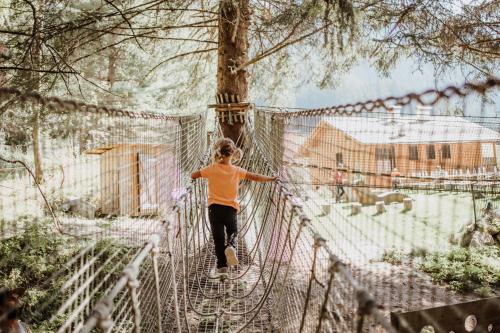 a person crossing a bridge on a suspension bridge at Familienhotel Huber in Valles