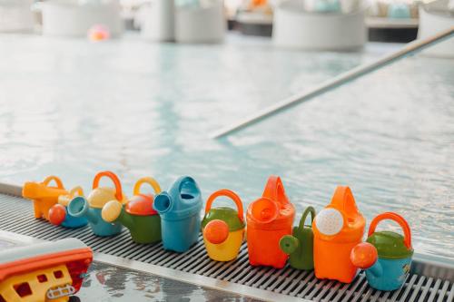 a group of toys sitting next to a swimming pool at Familienhotel Huber in Valles