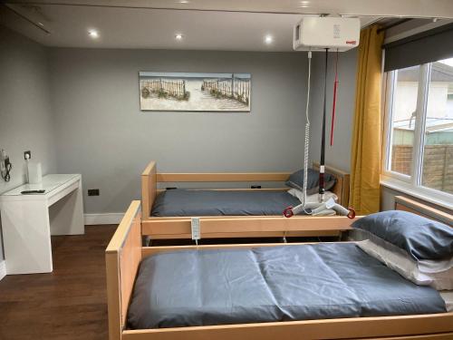 a bedroom with two bunk beds and a window at Fully Accessible - Disability Adapted Holiday Cottage - Skegness in Ingoldmells