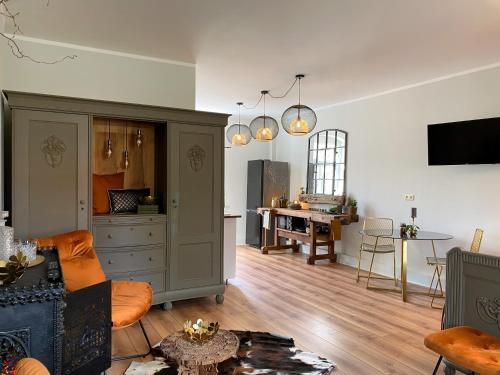 a living room with a cabinet and a table at ALTE SCHULE WITTENBERG, 3 Ferienwohnungen für bis zu 12 Personen, an der Elbe, mit Garten in Lutherstadt Wittenberg