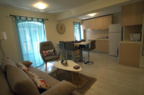 ein Wohnzimmer mit einem Sofa und einem Tisch sowie eine Küche in der Unterkunft Piccolo Centrale in Korfu-Stadt