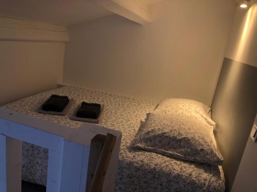 1 dormitorio pequeño con 1 cama con 2 almohadas en L'instant d'une pause Studio mezzanine avec jardin proche Montpellier, en Teyran