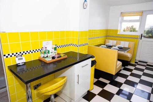 a bathroom with yellow and black tiled walls at Alexander Apartments Northumberland in Blythe