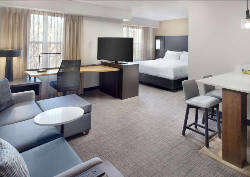 um quarto de hotel com uma cama e uma sala de estar em Sonesta ES Suites Raleigh Durham Airport Morrisville em Morrisville