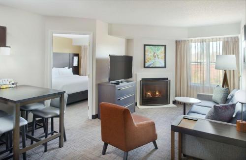 a hotel room with a bed and a living room at Sonesta ES Suites Raleigh Durham Airport Morrisville in Morrisville
