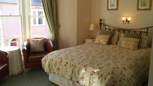 A bed or beds in a room at MYRTLE HOUSE HOTEL TENBY