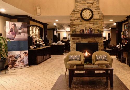 a living room with a fireplace and a clock at Sonesta ES Suites San Jose - Airport in San Jose