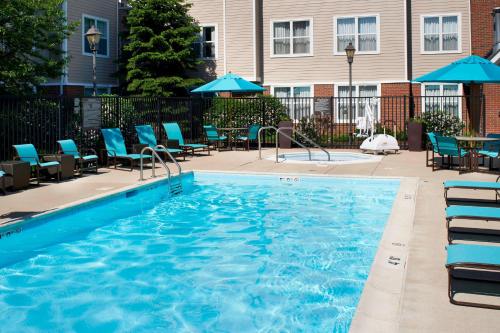 a large swimming pool with chairs and umbrellas at Sonesta ES Suites Chicago Waukegan Gurnee in Waukegan