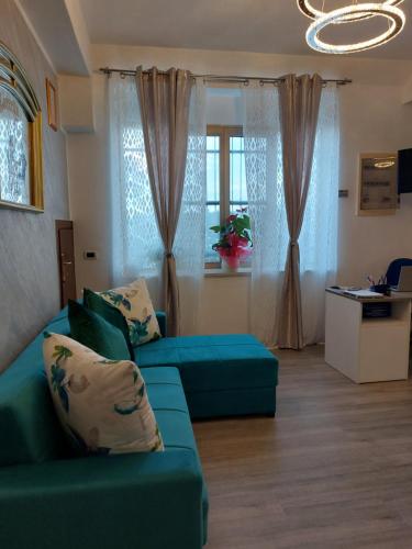 salon z zieloną kanapą i oknem w obiekcie Bed And Breakfast Torretta w mieście Controguerra