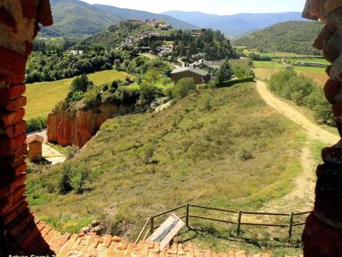 a view from a window of a hill with a town at Hotel Restaurante La Glorieta in La Seu d'Urgell