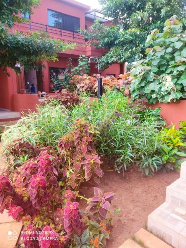 a garden with flowers in front of a building at Appartement lumineux avec balcon à Porto-Novo, 65 m² in Porto-Novo