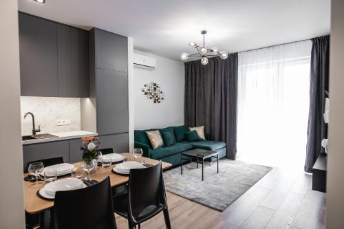 MKM Apartments Lublin في لوبلين: غرفة معيشة مع طاولة وأريكة خضراء
