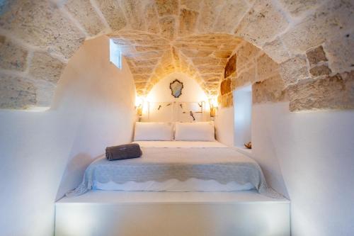 a bedroom with a bed in a stone wall at BELLE HOME OSTUNI vasca vista mare in Ostuni