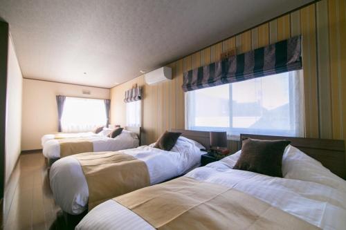 Habitación de hotel con 3 camas y ventana en Minamitsuru-gun - House - Vacation STAY 82499, en Fujikawaguchiko