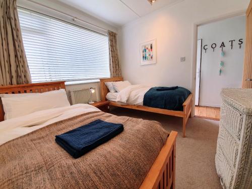 a bedroom with two beds and a window at Hoblyns Cove in Holywell Bay
