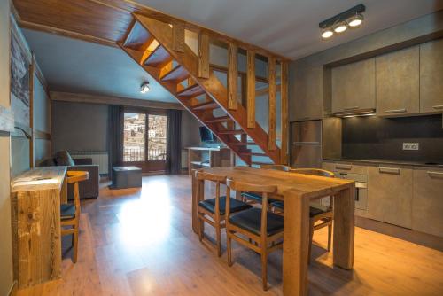 a kitchen with a wooden staircase and a table at Hotel AnyosPark Mountain & Wellness Resort in Anyós