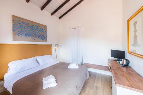 a bedroom with a large bed and a television at Hotel Villino Gallodoro in Taormina