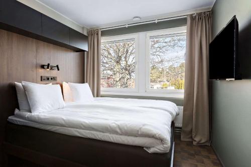 Un dormitorio con una cama grande y una ventana en Sure Hotel Studio by Best Western Bromma, en Estocolmo