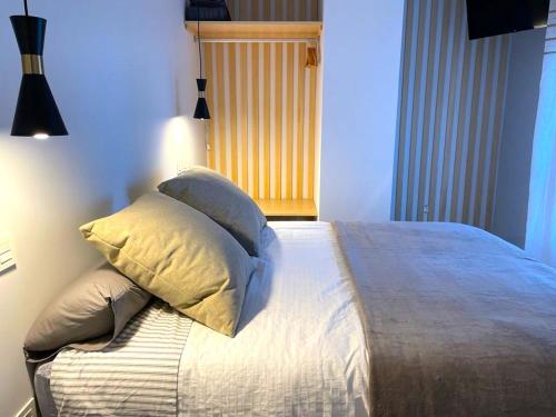 una camera da letto con un letto con cuscini sopra di Apartamentos Aranda - VUT- La Cepa I - II ad Aranda de Duero