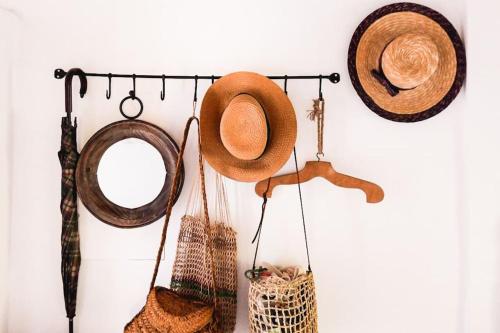 a group of hats hanging on a wall at Lobeira - Centenary country house and gardens in Beja