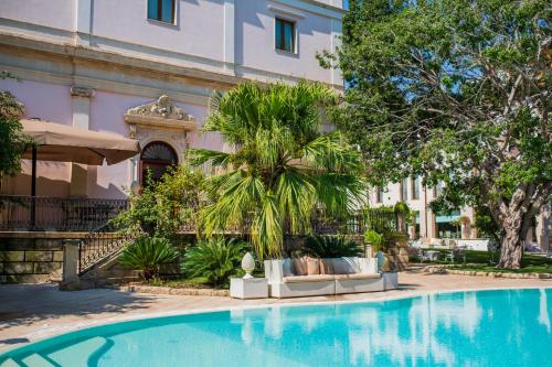 a swimming pool in front of a building at Hotel Parco delle Fontane in Siracusa