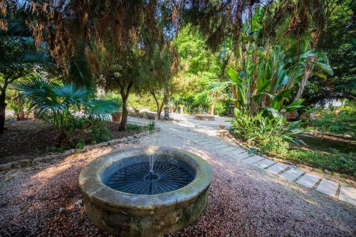 a stone fountain in the middle of a park at Hotel Parco delle Fontane in Siracusa