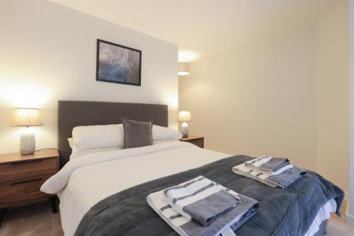 a bedroom with a large bed with towels on it at Southbank Leeds Apartment. New! With Free Parking in Leeds