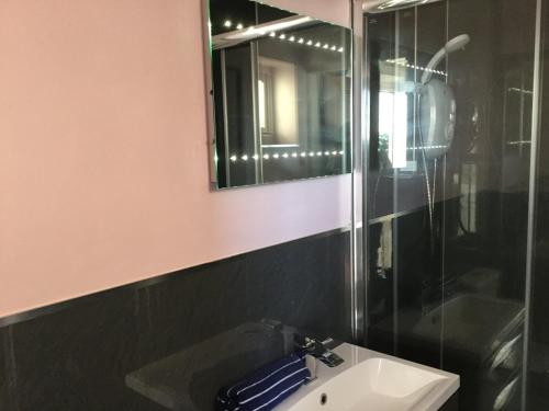 a bathroom with a sink and a mirror at Talarfor Barmouth in Barmouth