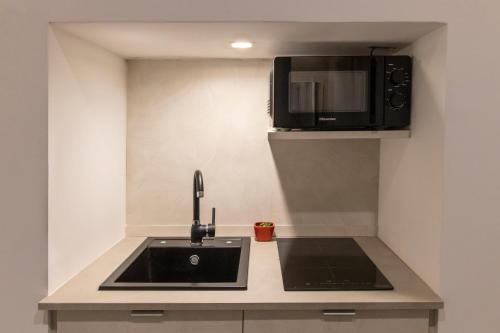 a kitchen with a sink and a microwave at Porta Vetere - Boutique Rooms in Trani