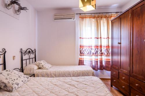 a bedroom with two beds and a dresser at Coqueto Alojamiento in Martos