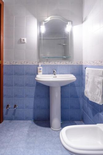 ein Badezimmer mit einem Waschbecken, einem Spiegel und einem WC in der Unterkunft Coqueto Alojamiento in Martos