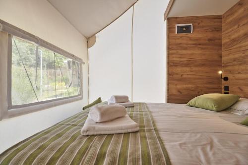 a bedroom with a large bed with pillows on it at Chalets & Glamping Nassfeld by ALPS RESORTS in Kötschach