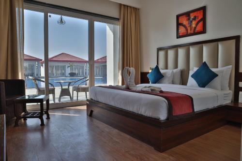 1 dormitorio con 1 cama y balcón con mesa en Mannat Resort Paota, en Prāgpura