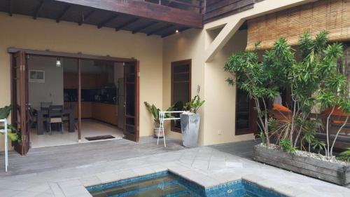 a house with a swimming pool and a patio at The BeachHouse Tanjung Lesung in Cipakus