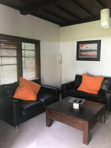 a living room with two leather couches and a coffee table at The BeachHouse Tanjung Lesung in Cipakus
