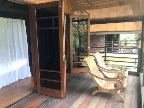a pair of chairs sitting on the porch of a house at The BeachHouse Tanjung Lesung in Cipakus
