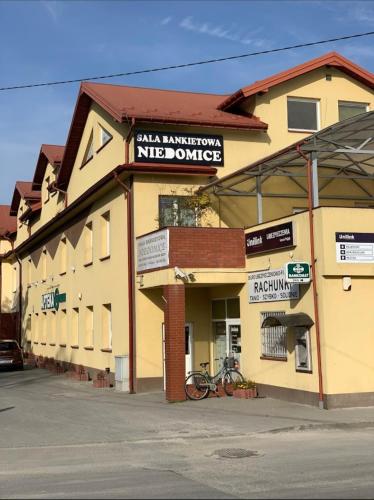 a building with a bike parked in front of it at Hostel Niedomice 