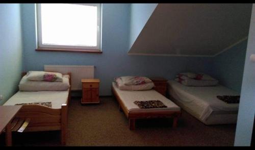 a room with two beds and a window at Hostel Niedomice 