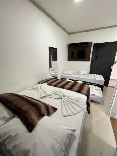 Habitación de hotel con 2 camas y baño en Penha Parque Pousada, en Penha