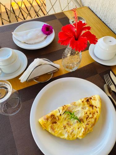eine weiße Platte mit einem Stück Essen auf dem Tisch in der Unterkunft Pousada Alma Noronha in Fernando de Noronha