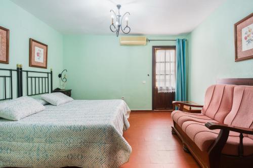 1 dormitorio con 1 cama y 1 sofá en Hotel Marqués de Torresoto by Vivere Stays, en Arcos de la Frontera