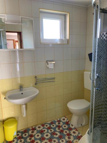 a bathroom with a sink and a toilet and a window at Apartments Novela in Poljanak