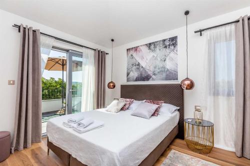 a bedroom with a bed and a large window at Luxury apartment Viktorija with private pool in Čižići
