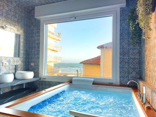 a large tub in a bathroom with a window at SWEET HOME & WELLNESS affittacamere in Nettuno