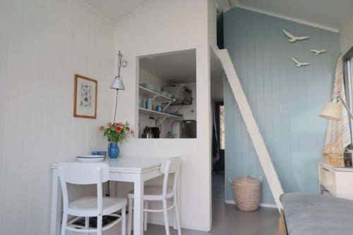 eine Küche und ein Esszimmer mit einem Tisch und Stühlen in der Unterkunft Slaapstrandhuisje - Strand dishoek 60 Dishoek in Vlissingen