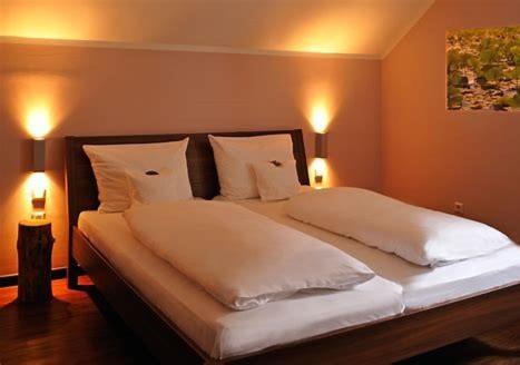 een slaapkamer met een bed met witte kussens en 2 verlichting bij Self CheckIn Hotel Heckenrose Lorin in Ringsheim