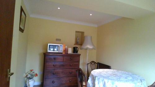 a bedroom with a dresser with a microwave on top of it at Madresfield in South Petherton
