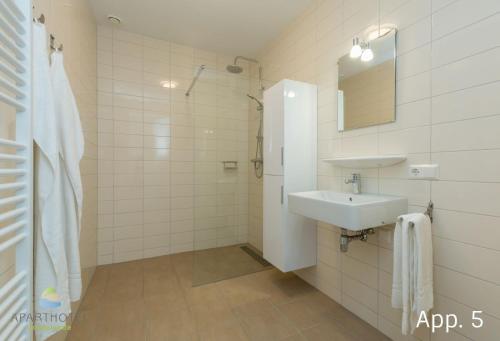 Baño blanco con lavabo y espejo en Luxury 4 person apartment pet allowed Zoutelande, en Zoutelande