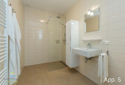 ein weißes Badezimmer mit Waschbecken und Spiegel in der Unterkunft Luxury 4 person apartment pet allowed Zoutelande in Zoutelande