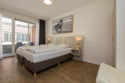 ein Schlafzimmer mit einem großen Bett und einem großen Fenster in der Unterkunft Luxury 4 person apartment pet allowed Zoutelande in Zoutelande